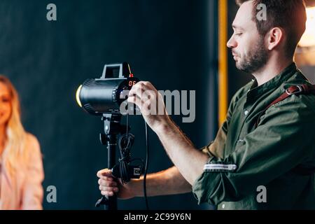 Junge Perlen Mann Einstellung der Blitz vor Foto-Session. Nahaufnahme Foto. Hobby, Lifestyle Stockfoto