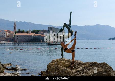 Tourist posiert für ein Foto in der Nähe der Statue Stockfoto