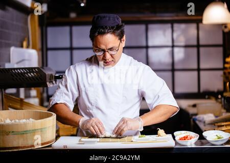 Attraktiver Mann, der Reis berührt. Grundzutaten für Sushi.close up Foto Stockfoto