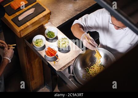 Von oben zugeschnittenes Foto des Küchenchefs im chinesischen Restaurant Stockfoto