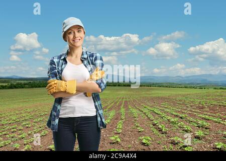 Bäuerin, die auf einem Feld mit jungen Sonnenblumenpflanzen steht Stockfoto