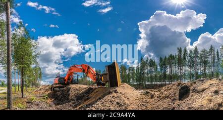 Panorama-Ansicht auf orange Bagger, der auf der Oberseite von Graben Sand gegraben steht. Voll gestreckten Arm mit Eimer liegt entlang der Schmutz in der Nähe des trenc Stockfoto