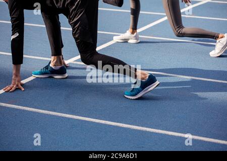 Nahaufnahme Seitenansicht Foto. Sport Menschen gehen bto nehmen an der kurzen Sprint. Seitenansicht abgeschnitten Foto Stockfoto