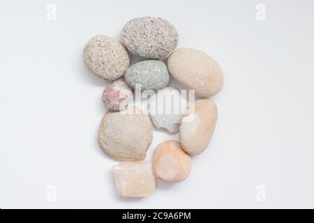 Stapel von dekorativen Steinen und Kieselsteinen auf dem weißen Hintergrund Stockfoto