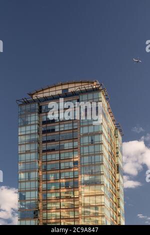 London, Großbritannien - 28. Juli 2020: Der Panoramawohnblock neben der Vauxhall Bridge in der Abendsonne mit einem vorbeifliegenden Flugzeug Stockfoto