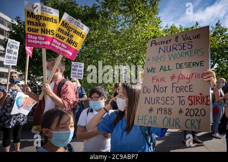 London, Großbritannien. Juli 2020. Coronavirus: NHS Marsch für Pay Justice. Hunderte von NHS-Arbeitern, Schlüsselarbeitern und Unterstützern marschieren vom St. Thomas' Hospital zu den Toren der Downing Street und fordern Lohngerechtigkeit. Die NHS-Arbeiter fordern, dass sie eine Lohnerhöhung für die seit 2010 um 20 % gesenkten Löhne verdienen und sich während der Pandemie COVID-19, die massenhaft Überstunden, Isolation von Familien und den Verlust von über 540 Arbeitnehmern durch das Virus sah, unterbewertet gefühlt haben. Kredit: Guy Corbishley/Alamy Live Nachrichten Stockfoto