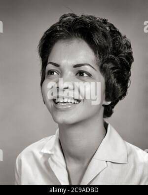 60S PORTRAIT BREIT LÄCHELND SELBSTBEWUSST AFROAMERIKANISCHE JUNGE FRAU AUGEN WERFEN NACH OBEN SCHAUEN HOFFNUNGSVOLL - N547 HAR001 HARS GELEGENHEIT LÄCHELT KONZEPTUELL FRÖHLICH STILVOLL ANGENEHM WACHSTUM NACH OBEN JUNGE ERWACHSENE FRAU SCHWARZ UND WEISS HAR001 ALTMODISCHE AFROAMERIKANER Stockfoto