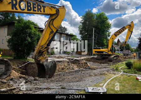 Bagger graben und füllen einen Graben auf einer Wohnstraße in Nepean Ontario für die Verlegung neuer Kanallinien Stockfoto