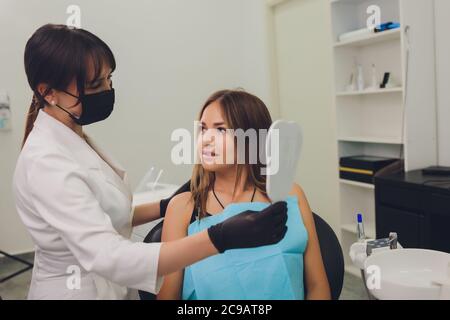 Die Patientin bewundert ihr Lächeln und schaut auf den Spiegel. Stockfoto