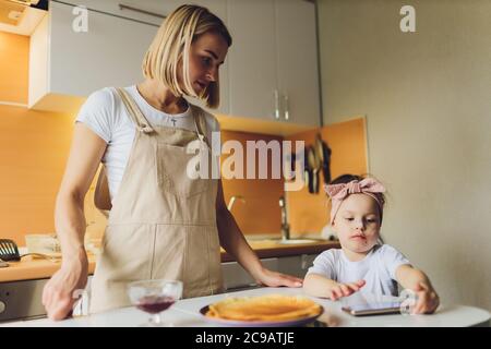 Mädchen essen am Tisch spielen am Telefon. Stockfoto