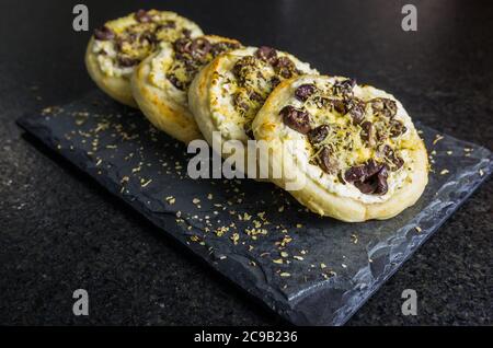 Köstliche libanesische (arabische) Speisen, mediterrane Ricotta Sfiha, Oliven au Gratin mit Käse auf schwarzem Granit Hintergrund. Stockfoto