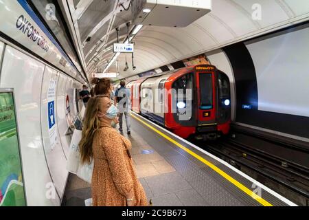 London, Großbritannien. Juli 2020. Die Menschen tragen Gesichtsmasken als vorbeugende Maßnahme an der U-Bahnstation Oxford Circus.die Regierung hat es zur Pflicht gemacht, Gesichtsbezüge an allen öffentlichen Verkehrsmitteln und an verschiedenen Orten wie Geschäften, Banken und Postämtern sowie Geschäften, Supermärkten, Indoor-Einkaufszentren und Bahnhöfen in England zu tragen. Kredit: Edward Crawford/SOPA Images/ZUMA Wire/Alamy Live Nachrichten Stockfoto