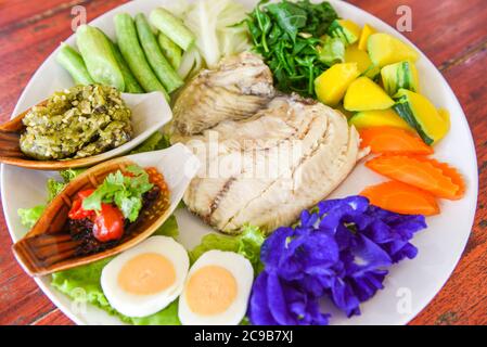 Gedünsteter Fisch mit Chilisauce gekochte Eier und Gemüse Kürbiskarotte auf weißem Teller / Thailand Food Asiatisch gekochter Tilapia-Fisch Stockfoto