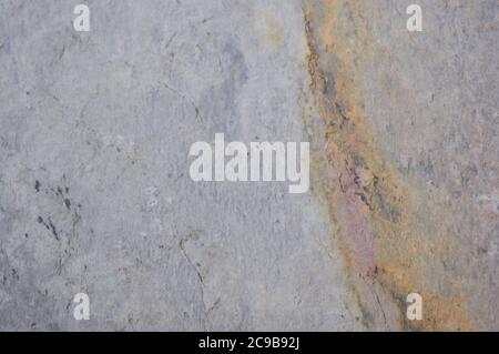 Grauer Sandstein mit einer großen Ader von hellbeige und Spuren von Erosion, die Textur eines Natursteins auf dem Schnitt. Nahaufnahme. Stockfoto