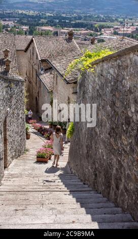 Frau, die in Gubbio, Umbrien, Italien, Treppen hinuntergeht Stockfoto