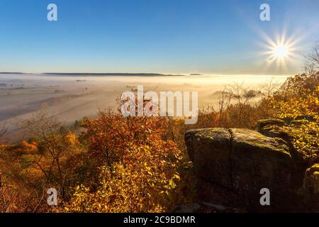 Die Sonne scheint über ein Tal mit Nebel im Herbst Stockfoto