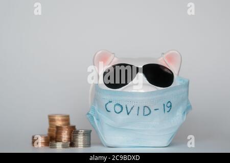 Der Zusammenbruch der Finanzmärkte und die Gefahr für finanzielle Ersparnisse aufgrund eines Pandemie-Virus.Masked Sparschwein Stockfoto