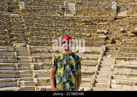 Schöner junger Mann in rotem Hut in Ephesus antiken Stadt