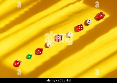 Würfel diagonal auf einem gelben Hintergrund, schönes Licht und Schatten. Ein Spiel mit Würfeln spielen. Das Würfelkonzept für Geschäftsrisiken. Stockfoto