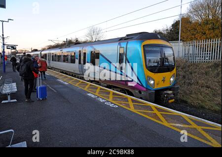 Passagiere, die in der Lackierung des Trans Pennine Express an Bord eines Desiro Diesel-Triebgeräts der Siemens-Klasse 185 in Thirsk Station, Yorkshire, Großbritannien, warten Stockfoto