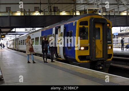 Passagiere, die am Bahnhof Leeds in einen Northern Trains der Klasse 158 Express DMU einsteigen Stockfoto