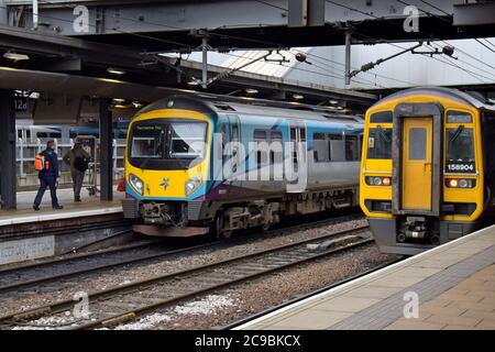 Eine TransPennine Express Class 185 Desiro DMU befindet sich neben einer Northern Trains Class 158 Express DMU am Bahnhof Leeds Stockfoto