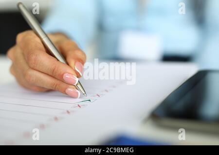 Weibliche Hände markieren mit Stift auf Papier Nahaufnahme Stockfoto