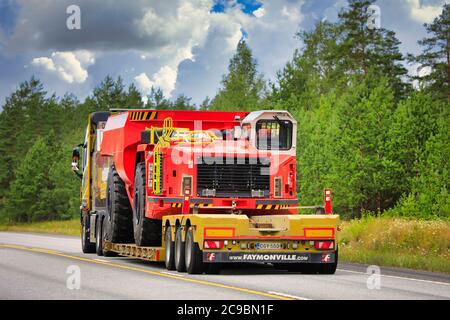 Gelber Volvo FH16 Sattelauflieger Mantyla E&E Ky transportiert Sandvik unterirdisch LKW für den Bergbau auf der Autobahn 25. Raasepori, Finnland. Juli 24, 2020. Stockfoto