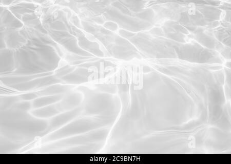Nahaufnahme der entsättigte transparente klare ruhige Wasseroberfläche Textur mit Spritzern und Blasen. Trendy abstrakt Natur Hintergrund. Stockfoto