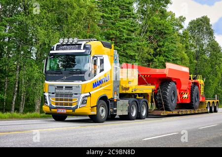 Gelber Volvo FH16 Sattelauflieger Mantyla E&E Ky transportiert Sandvik unterirdisch LKW für den Bergbau auf der Autobahn 25. Raasepori, Finnland. Juli 24, 2020. Stockfoto