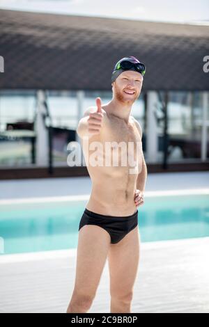 Mann im Badeanzug zeigt Geste alles ist in Ordnung. Stockfoto