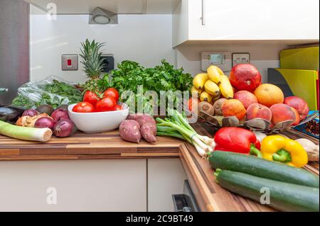 Fülle von frischem Gemüse und Obst auf der Arbeitsplatte der Küche. Stockfoto
