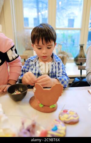 Kinderhände machen Lebkuchen. Kinder schneiden Kekse. Kinder backen Plätzchen Stockfoto