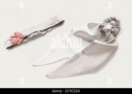 Slver oder graue Haaraccessoires mit Textil-Rose. Seide Scrunchy isoliert auf weißem Hintergrund. Flat Lay Friseur Werkzeuge und Zubehör für Frau - Stockfoto