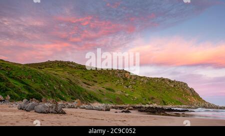 Ein pastellfarbener Sonnenuntergang über dem Rosetta Bluff vom Strand in Petrel Cove auf der Fleurieu Peninsula Victor Harbor South Australia am 28 2020. Juli Stockfoto