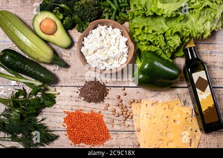 Eine Reihe von richtigen Lebensmitteln: Avocado, Kichererbsen, Quark, grünes Gemüse, Linsen, Olivenöl, Leinsamen Stockfoto