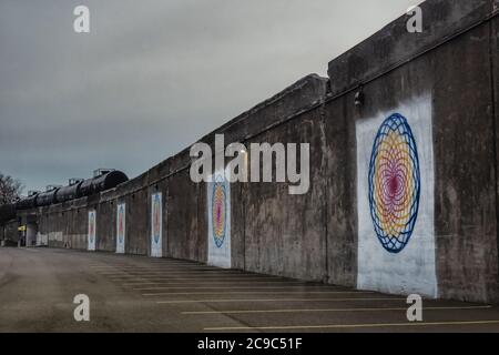 Farbenfrohe Spiralgemälde an der Wand einer erhöhten Eisenbahnstrecke in der Innenstadt von Syracuse, New york an einem düsteren, bewölkten Morgen Stockfoto