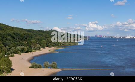 Hamburg, Deutschland. Juli 2020. Menschen laufen oder liegen am Elbstrand nahe dem Falkensteiner Ufer (Luftaufnahme mit Drohne). Im Hintergrund sehen Sie den Airbus-Werksstandort und den Hamburger Hafen. Quelle: Jonas Walzberg/dpa/Alamy Live News Stockfoto