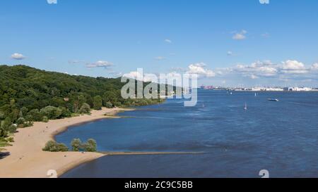 Hamburg, Deutschland. Juli 2020. Menschen laufen oder liegen am Elbstrand nahe dem Falkensteiner Ufer (Luftaufnahme mit Drohne). Im Hintergrund sehen Sie den Airbus-Werksstandort und den Hamburger Hafen. Quelle: Jonas Walzberg/dpa/Alamy Live News Stockfoto