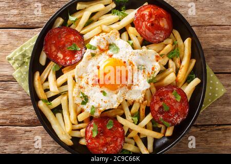 Huevos Rotos Rezept: Spanische zerbrochene Eier mit Kartoffel und Chorizo Wurst close-up in einem Teller auf dem Tisch. Horizontale Draufsicht von oben Stockfoto