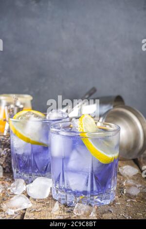 Lavendel alkoholischer Cocktail, Lavandula Limonade mit Zitrone und Honig, auf Holzhintergrund mit Lavendel Bund und Barmen Utschablonen, Kopierraum Stockfoto