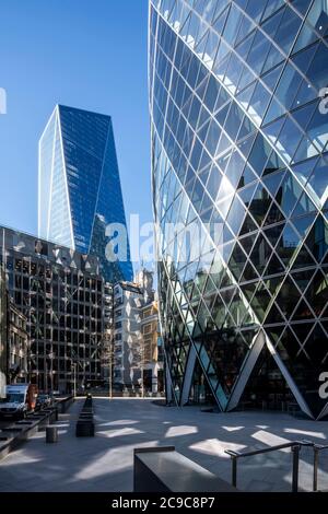 Blick nach Westen von Bury Street auf den Raum am Fuße des Gherkin, dann der Skalpell. Reflexionen von der Gherkin fallen auf benachbarten Gebäude Stockfoto