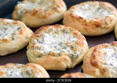 Öffnen Sie Brötchen mit Käse und Kräutern frisch aus dem Ofen gebacken. Nahaufnahme. Stockfoto