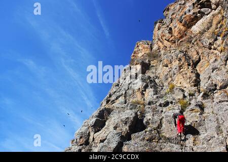 Kletterszene, Kletterer hängt am Seil. Sport und Unterhaltung Situation in Khazbegi, Georgien. Tag und Sommer. Stockfoto