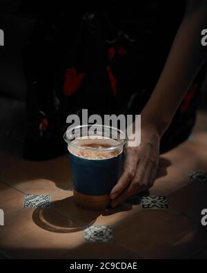 Frau hält Eiskaffee im Café. Stockfoto