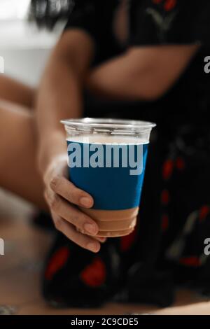 Frau hält Eiskaffee im Café. Stockfoto