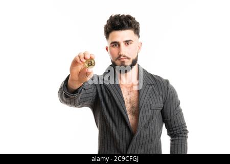 Ein Geschäftsmann in einem Anzug hält in der Hand A Gold Bitcoin isoliert auf weißem Hintergrund Stockfoto
