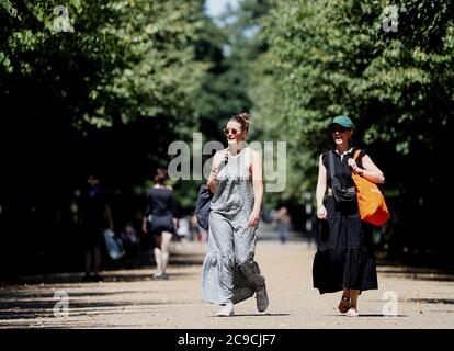 Die Besucher werden bei ihrem Spaziergang durch den Regent's Park in London in Sonnenschein getaucht. Stockfoto
