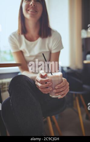 Frau trinken rosa Matcha Latte mit Milch in Cafe.Relaxation mood.verschwommenes Bild, selektiver Fokus Stockfoto