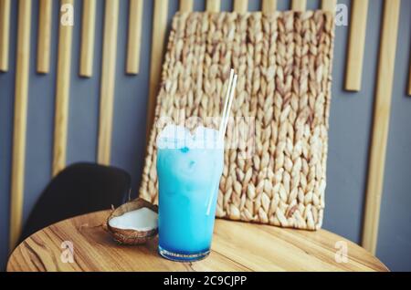 Blue hawaii Cocktail und Kokosnuss auf dem Tisch in der Bar. Verschwommenes Bild, selektiver Fokus Stockfoto